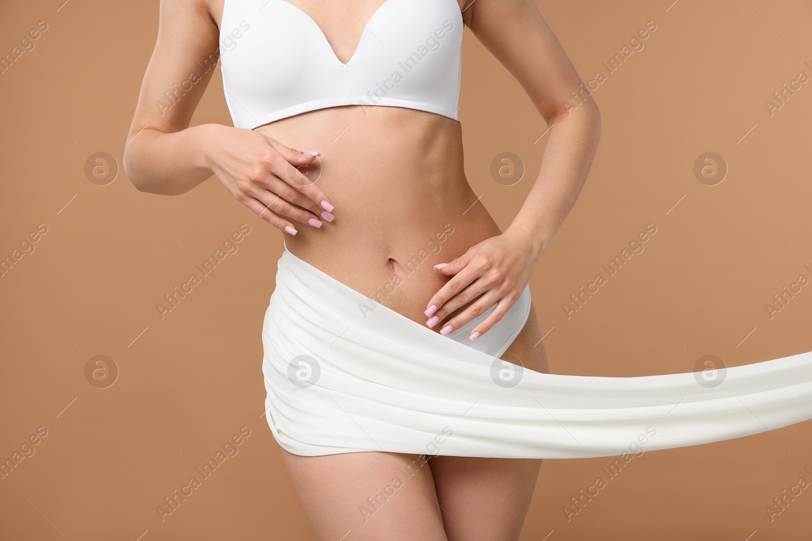Woman with beautiful fabric on beige background, closeup Photo of Woman with beautiful fabric on beige background, closeup