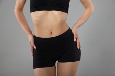 Photo of Woman with perfect slim body on gray background, closeup