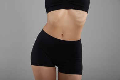 Photo of Woman with perfect slim body on gray background, closeup