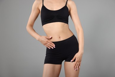 Photo of Woman with perfect slim body on gray background, closeup