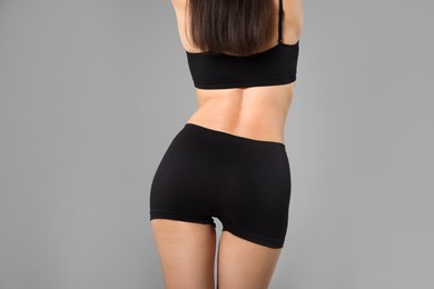 Photo of Woman with perfect slim body on gray background, closeup