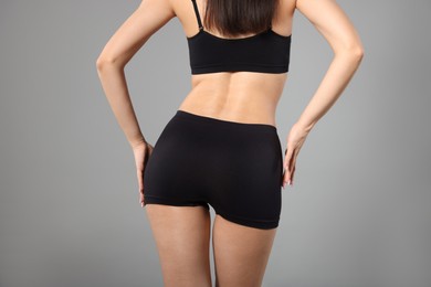 Photo of Woman with perfect slim body on gray background, closeup