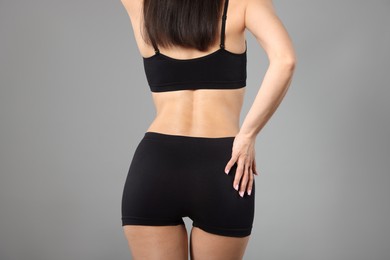 Photo of Woman with perfect slim body on gray background, closeup