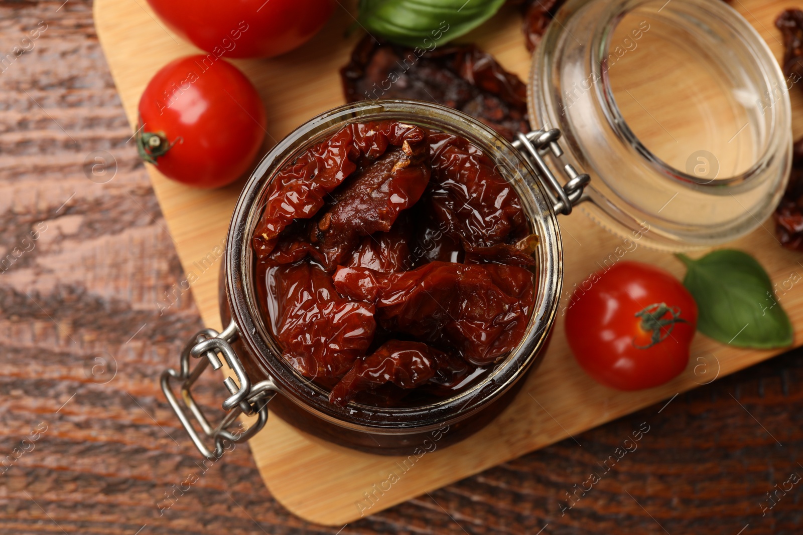 Tasty sun dried tomatoes and fresh vegetables on wooden table, top view Photo of Tasty sun dried tomatoes and fresh vegetables on wooden table, top view