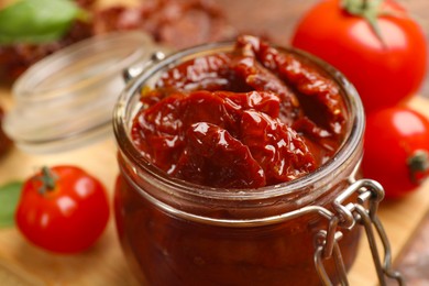 Photo of Tasty sun dried tomatoes and fresh vegetables on table, closeup