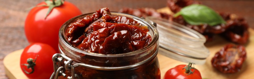 Photo of Tasty sun dried tomatoes and fresh vegetables on table, closeup