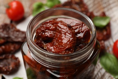 Photo of Tasty sun dried tomatoes and fresh vegetables on table, closeup