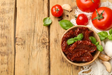 Photo of Tasty sun dried tomatoes, fresh vegetables and peppercorns on wooden table, flat lay. Space for text