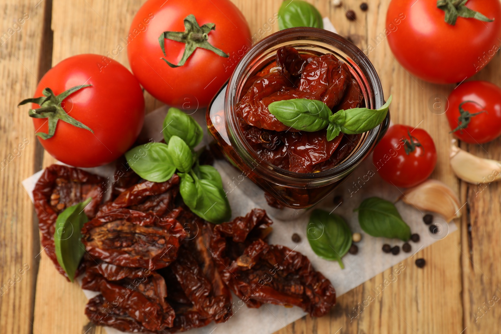 Tasty sun dried tomatoes, fresh vegetables and peppercorns on wooden table, flat lay Photo of Tasty sun dried tomatoes, fresh vegetables and peppercorns on wooden table, flat lay