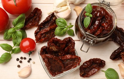 Photo of Tasty sun dried tomatoes, fresh vegetables and peppercorns on light wooden table, top view