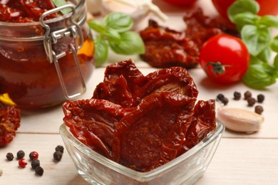 Photo of Tasty sun dried tomatoes, fresh vegetables and peppercorns on light wooden table, closeup