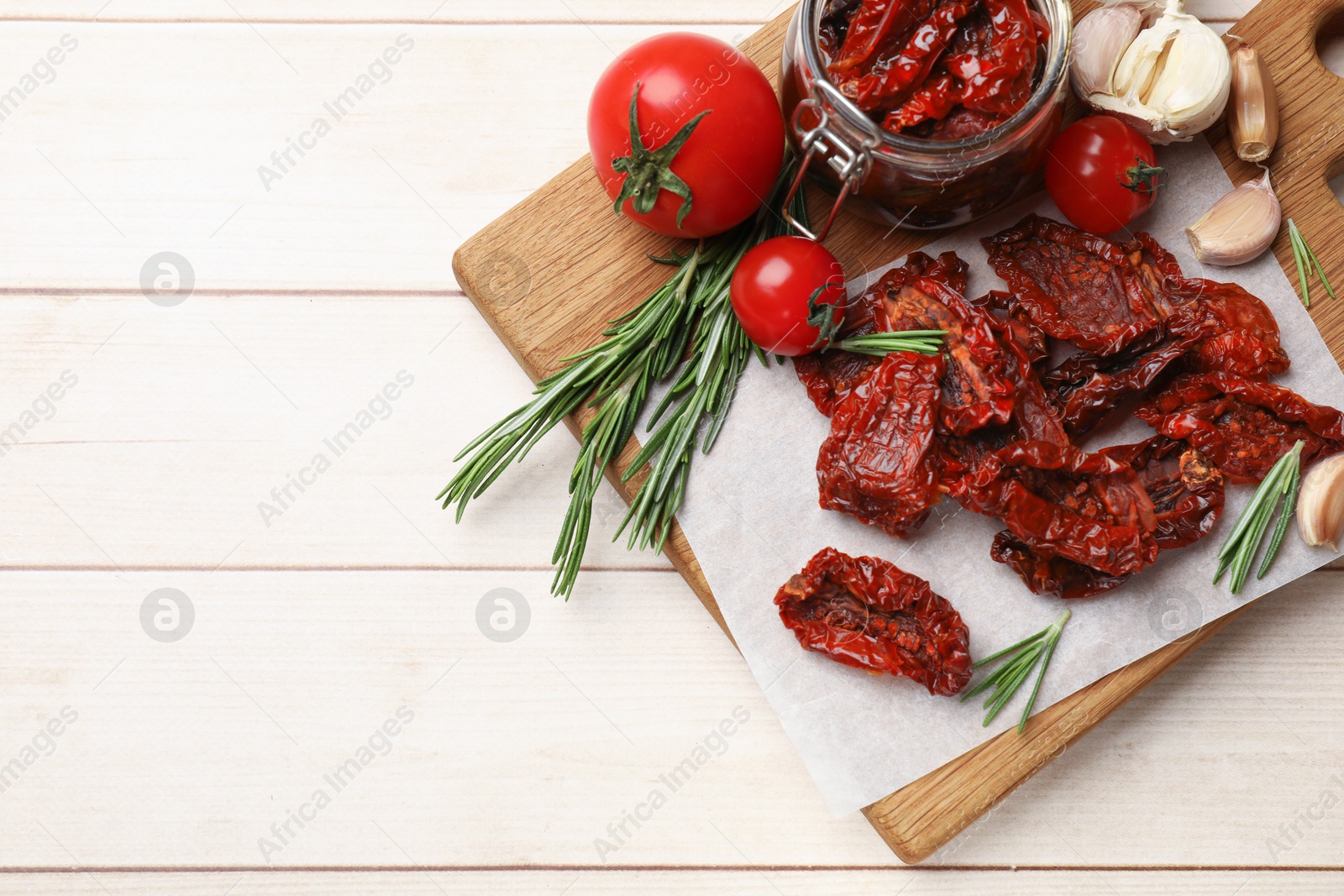 Tasty sun dried tomatoes and fresh vegetables on light wooden table, top view. Space for text Photo of Tasty sun dried tomatoes and fresh vegetables on light wooden table, top view. Space for text
