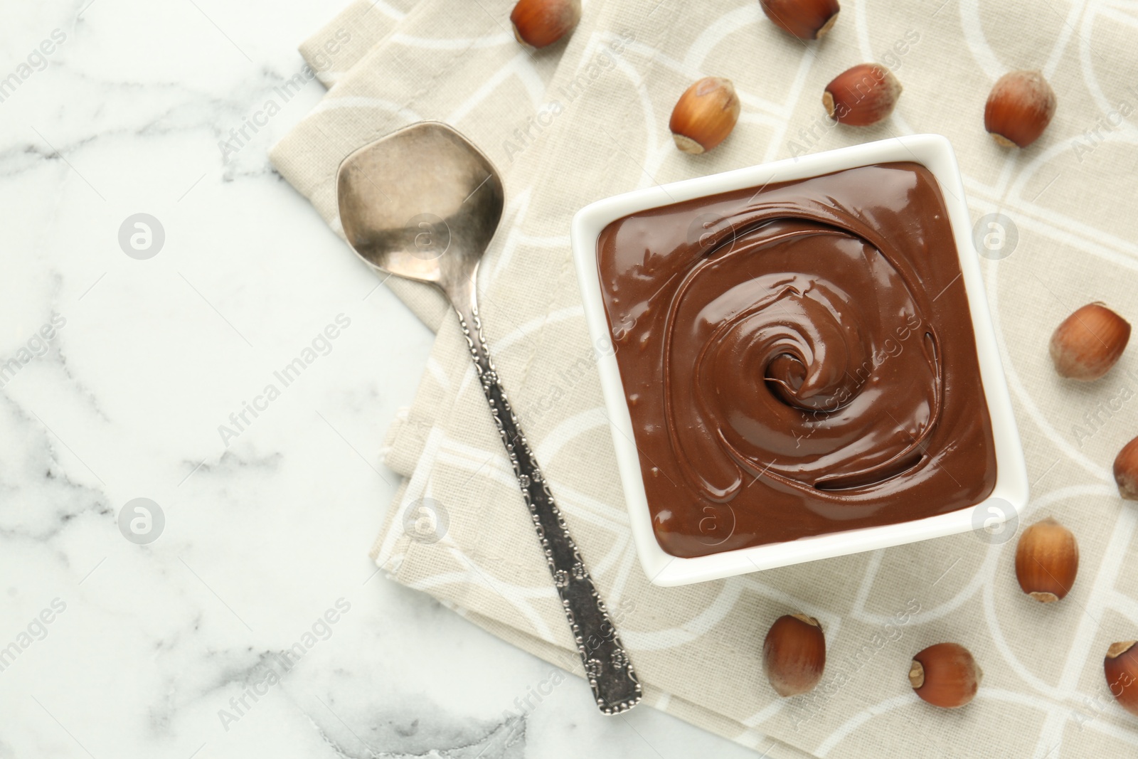 Tasty chocolate spread and hazelnuts on table, flat lay. Space for text Photo of Tasty chocolate spread and hazelnuts on table, flat lay. Space for text