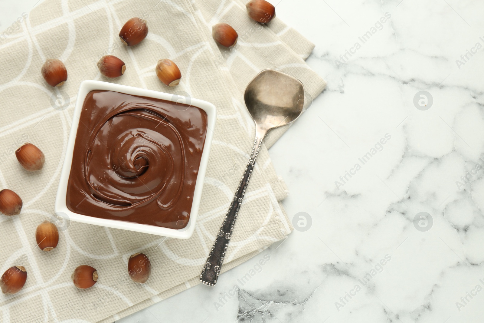 Tasty chocolate spread and hazelnuts on table, flat lay. Space for text Photo of Tasty chocolate spread and hazelnuts on table, flat lay. Space for text