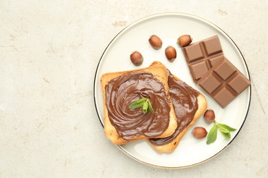 Photo of Toasts with tasty chocolate spread, pieces, mint and hazelnuts on light table, top view. Space for text