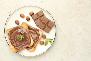 Photo of Toasts with tasty chocolate spread, pieces, mint and hazelnuts on light table, top view. Space for text