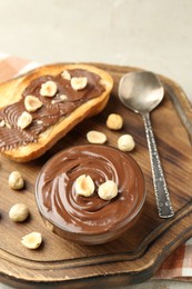 Photo of Toasts with tasty chocolate spread and hazelnuts on light table, closeup