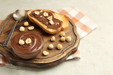 Photo of Toasts with tasty chocolate spread and hazelnuts on light table, closeup