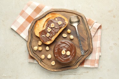 Photo of Toasts with tasty chocolate spread and hazelnuts on light table, top view