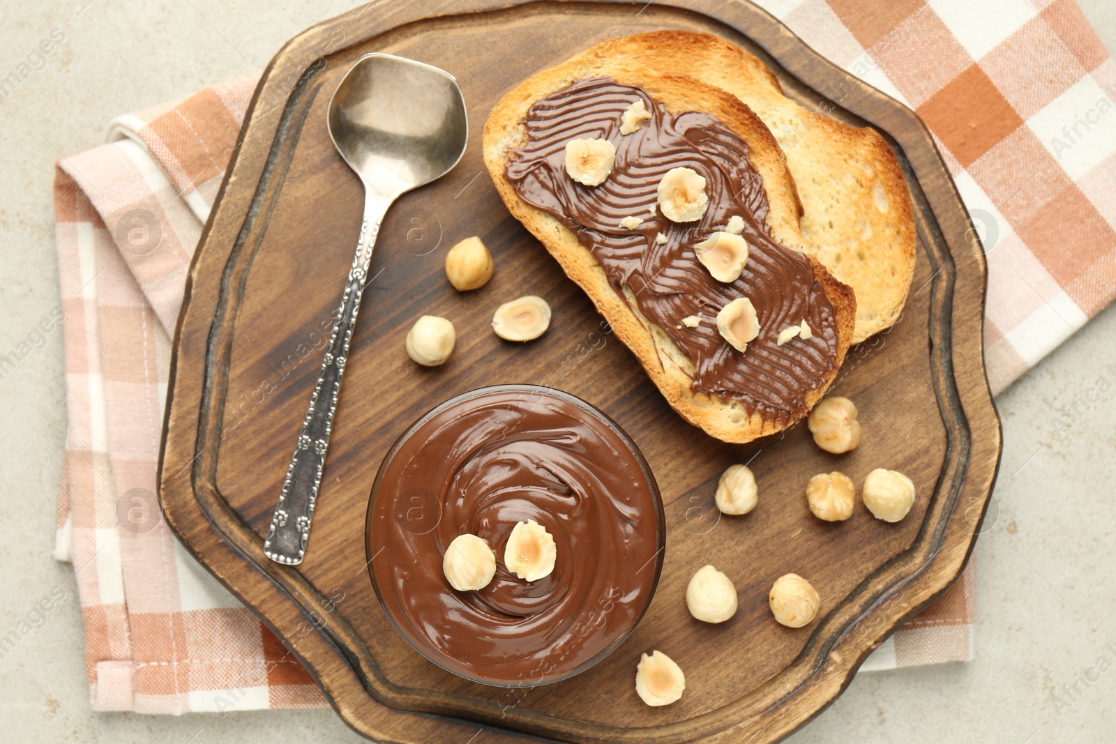 Toasts with tasty chocolate spread and hazelnuts on light table, top view Photo of Toasts with tasty chocolate spread and hazelnuts on light table, top view