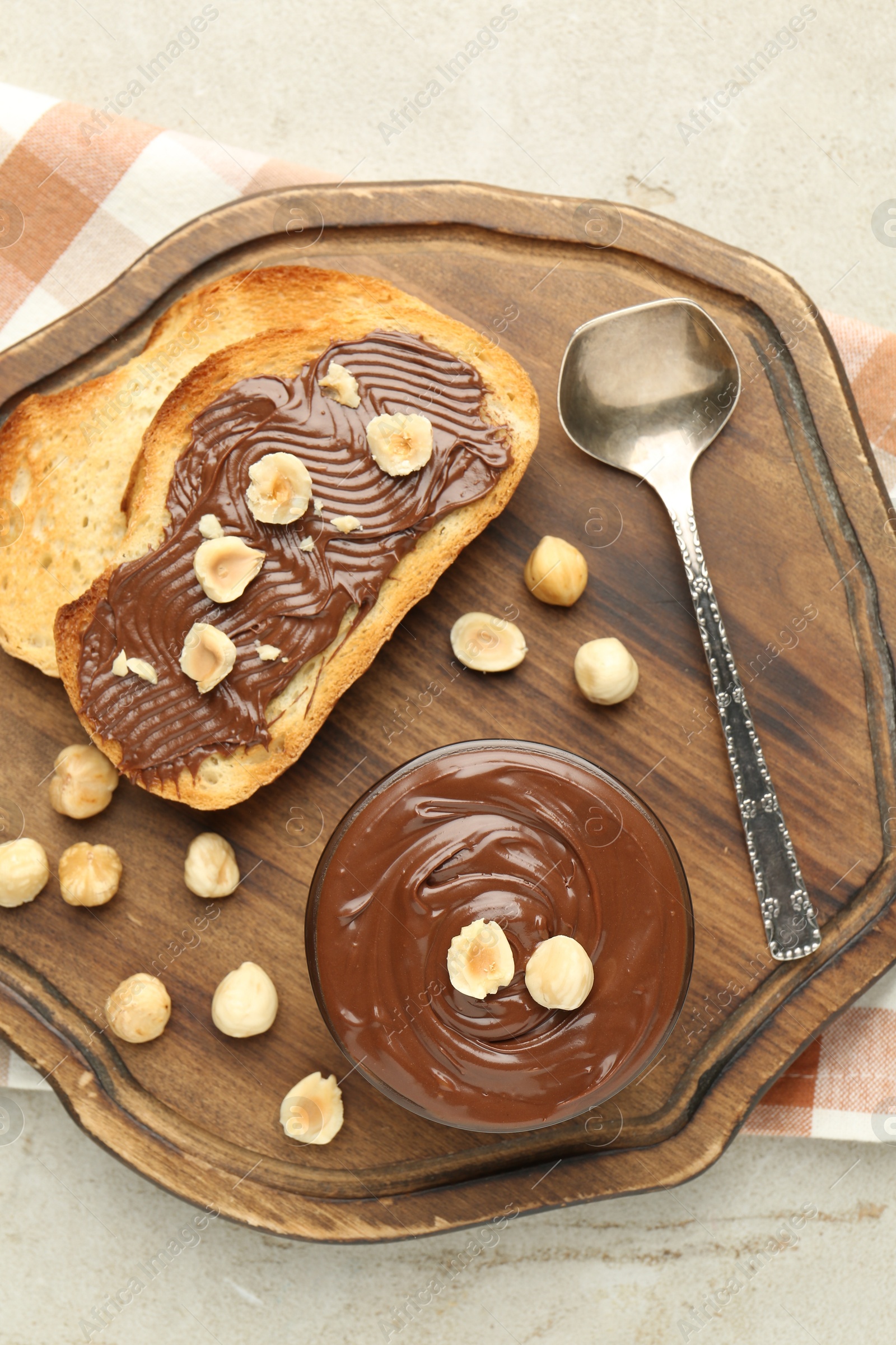 Toasts with tasty chocolate spread and hazelnuts on light table, top view Photo of Toasts with tasty chocolate spread and hazelnuts on light table, top view