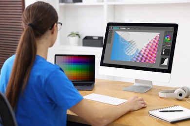 Image of Designer working on different computers at table in office