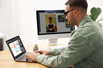 Image of Designer working on different computers at table in office
