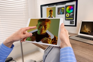 Image of Designer working on different devices at table in office. Man using tablet computer, closeup