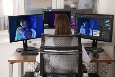 Image of Designer working on different computers at table in office, back view