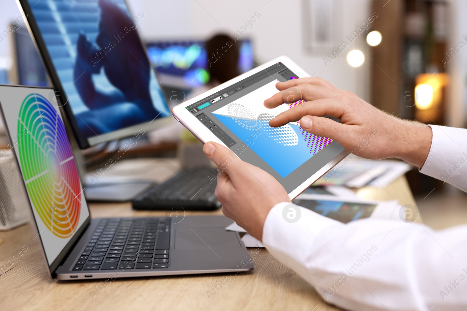 Designer working on different devices at table in office. Man using tablet computer, closeup Image of Designer working on different devices at table in office. Man using tablet computer, closeup