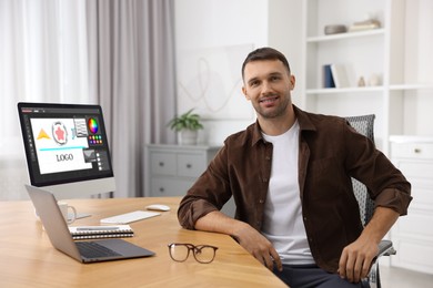 Image of Designer working on different computers at table in office
