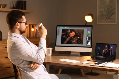 Image of Designer working on different computers at table in office