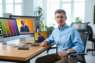 Image of Designer working on different computers at table in office