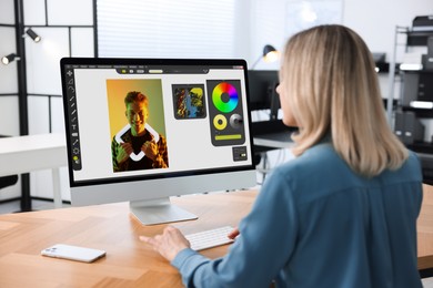 Image of Designer working on computer at table in office