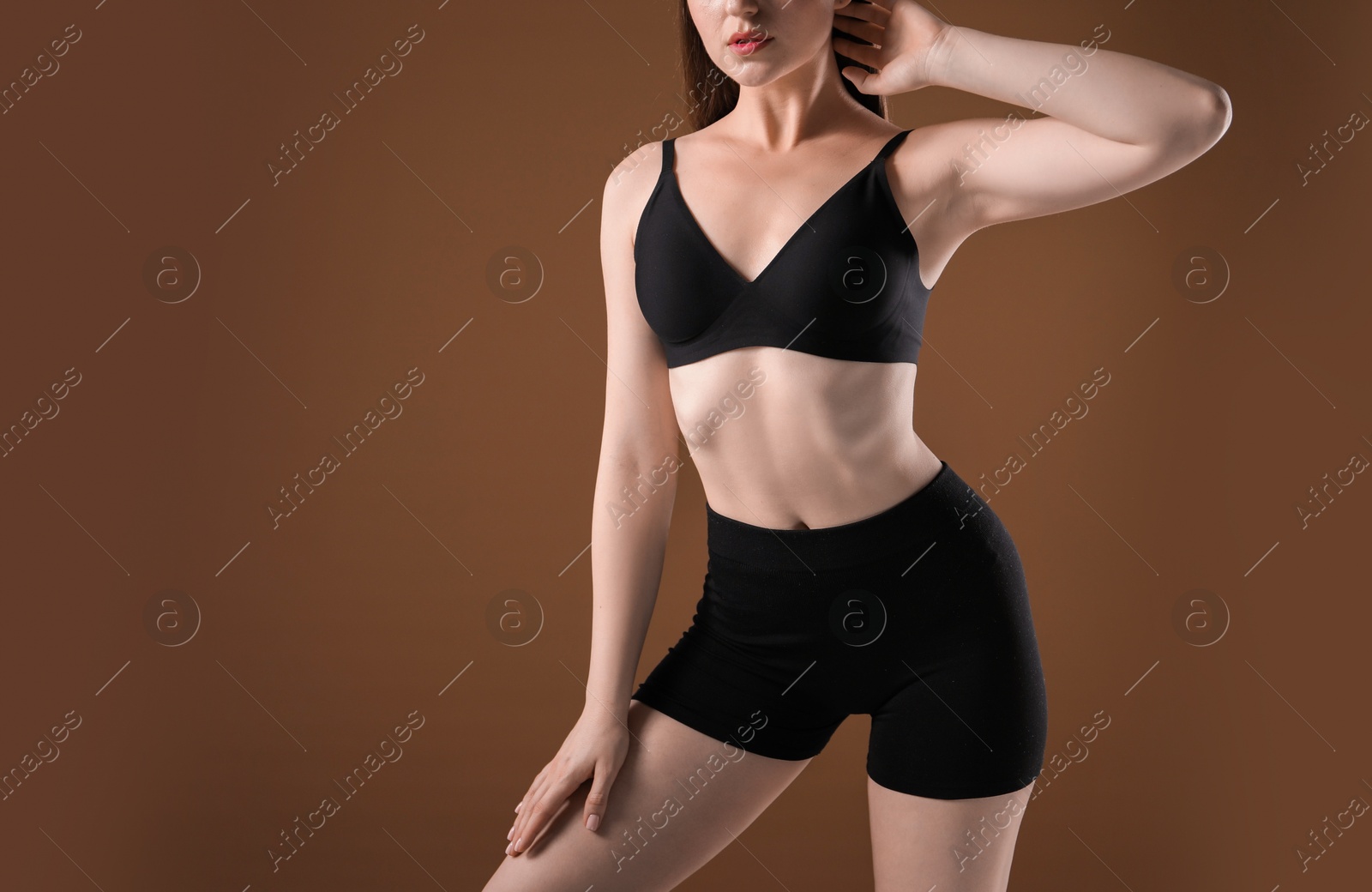 Woman with beautiful body on brown background, closeup. Space for text Photo of Woman with beautiful body on brown background, closeup. Space for text