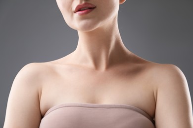 Photo of Woman with beautiful collarbones and neck on grey background, closeup