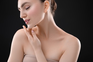 Photo of Woman with beautiful collarbones and neck on black background, closeup