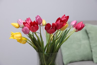 Photo of Beautiful colorful tulips in vase indoors, closeup