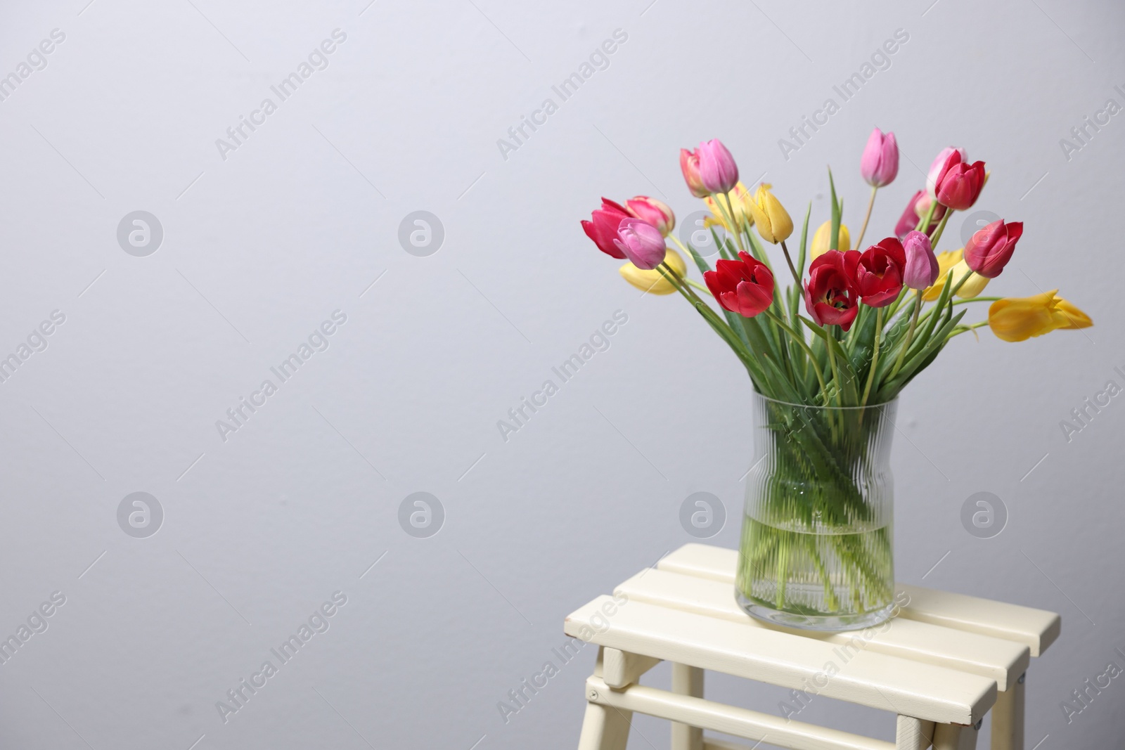 Photo of Bouquet of beautiful tulips on table indoors. Space for text