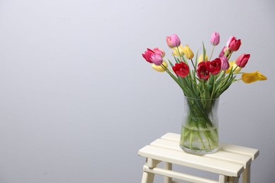 Photo of Bouquet of beautiful tulips on table indoors. Space for text
