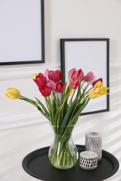 Photo of Bouquet of beautiful tulips and decor on table indoors