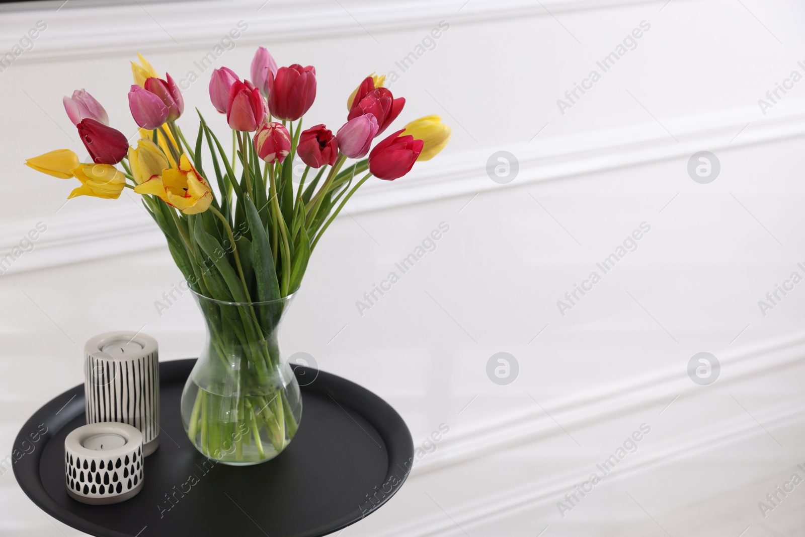 Photo of Bouquet of beautiful tulips and decor on table indoors. Space for text