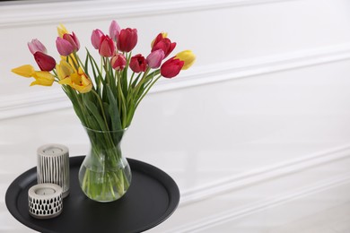 Photo of Bouquet of beautiful tulips and decor on table indoors. Space for text