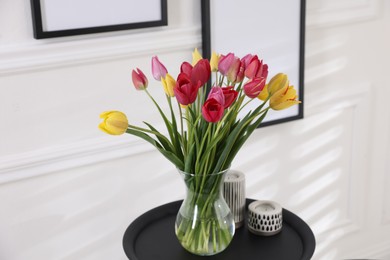 Photo of Bouquet of beautiful tulips and decor on table indoors