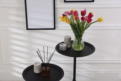 Photo of Bouquet of beautiful tulips and decor on tables indoors