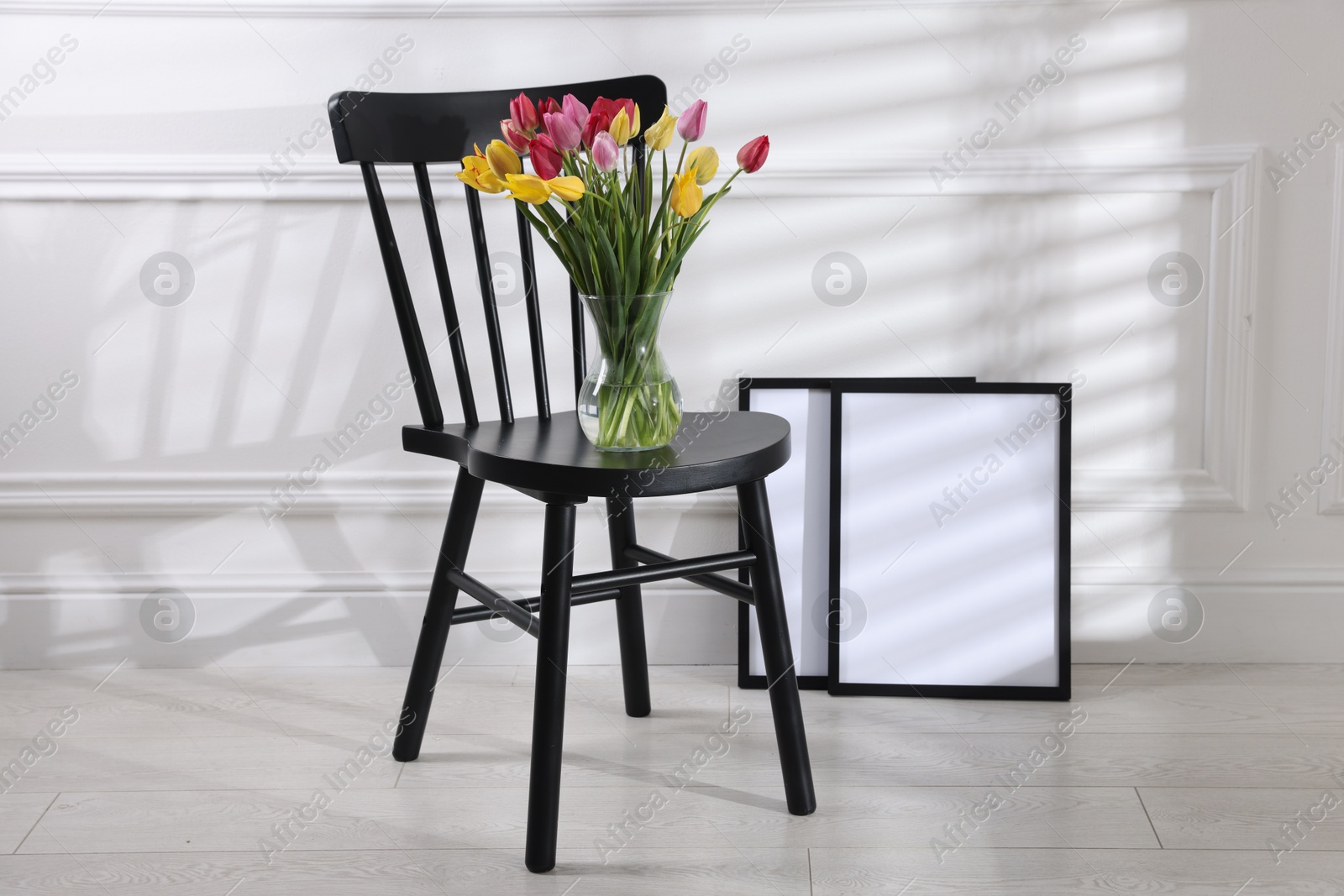 Photo of Bouquet of beautiful colorful tulips on chair indoors
