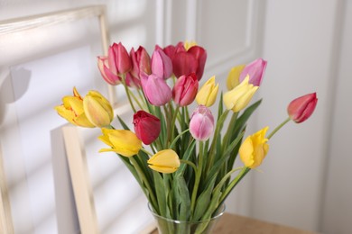 Photo of Bouquet of beautiful tulips on table indoors, closeup