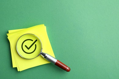 Image of Approved. Yellow paper note with check mark and magnifying glass on green background. top view. Space for text