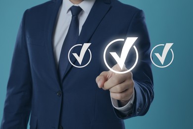 Image of Approved. Man touching check mark on virtual screen against pastel blue background, closeup
