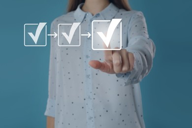 Image of Approved. Woman touching check mark on virtual screen against pastel blue background, closeup